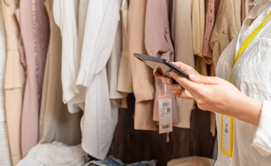 A female owner of a clothing shop with a tablet in her hands​