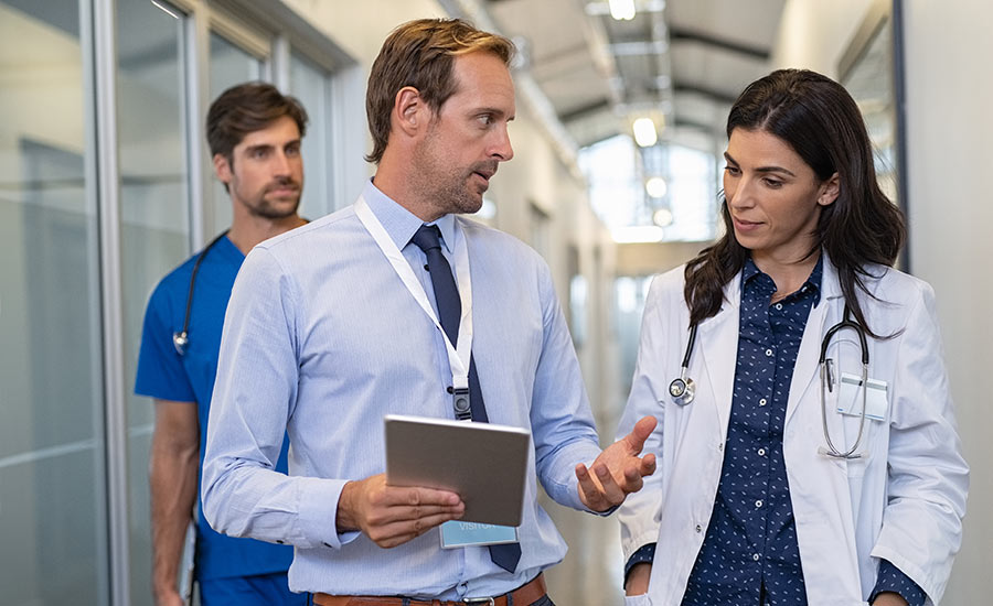 Two health workers discussing a business workflow document on a mobile electronic form​