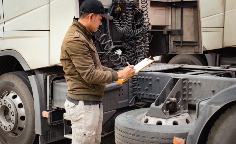 A man checking a truck before going out on the road​