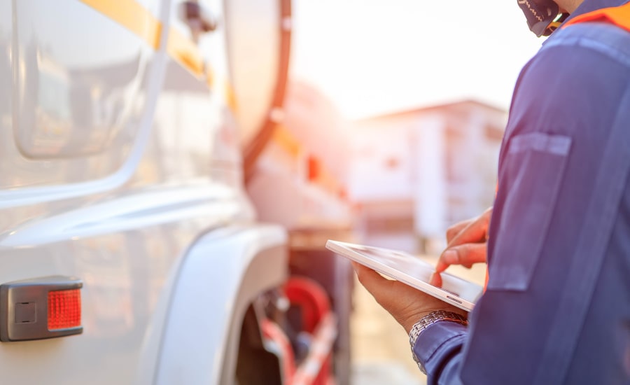 A man performing a truck inspection using a tablet