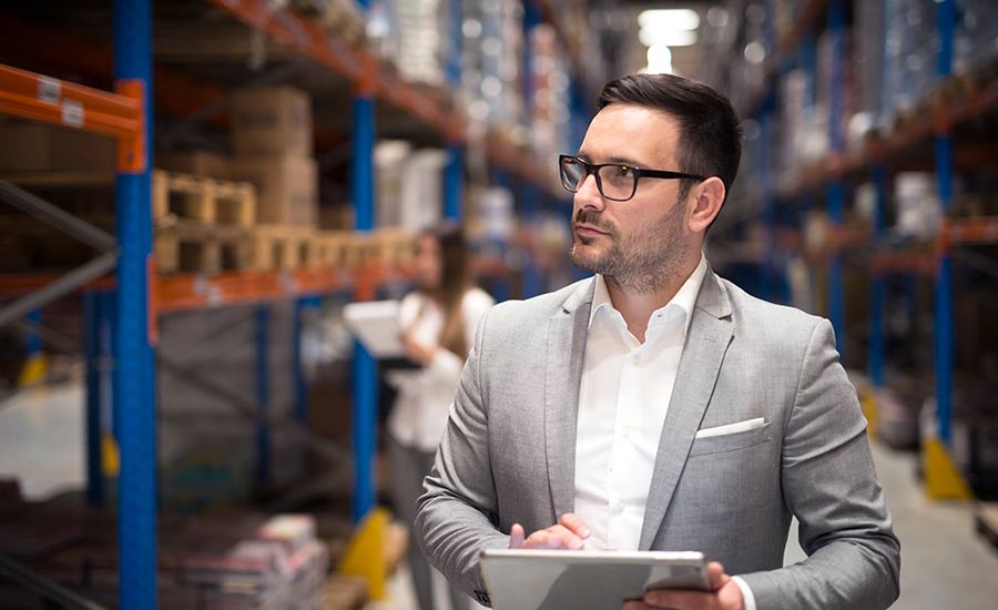 An image showing a manager touring the workplace and taking notes