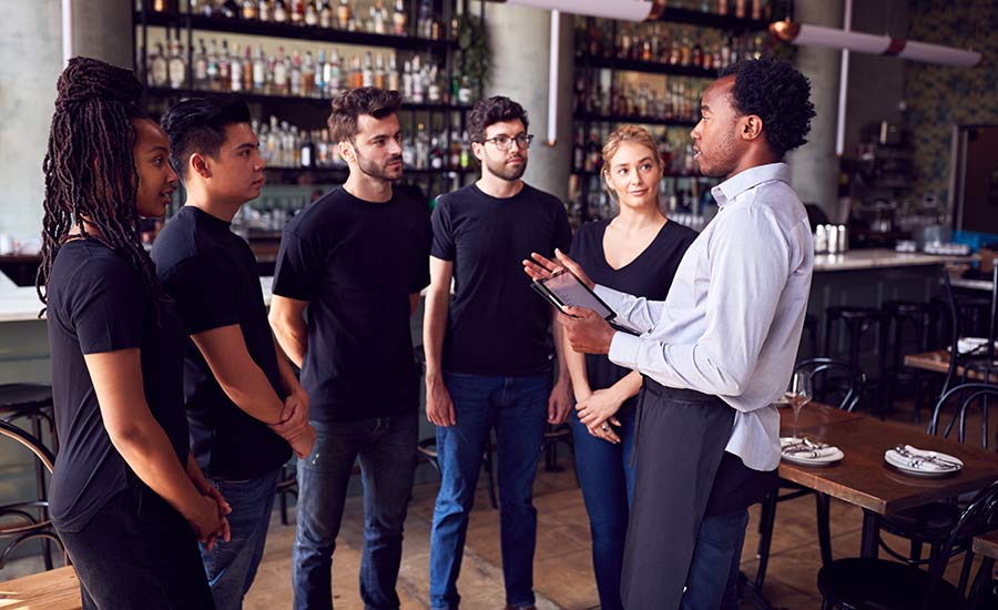 A restaurant manager talking to his staff