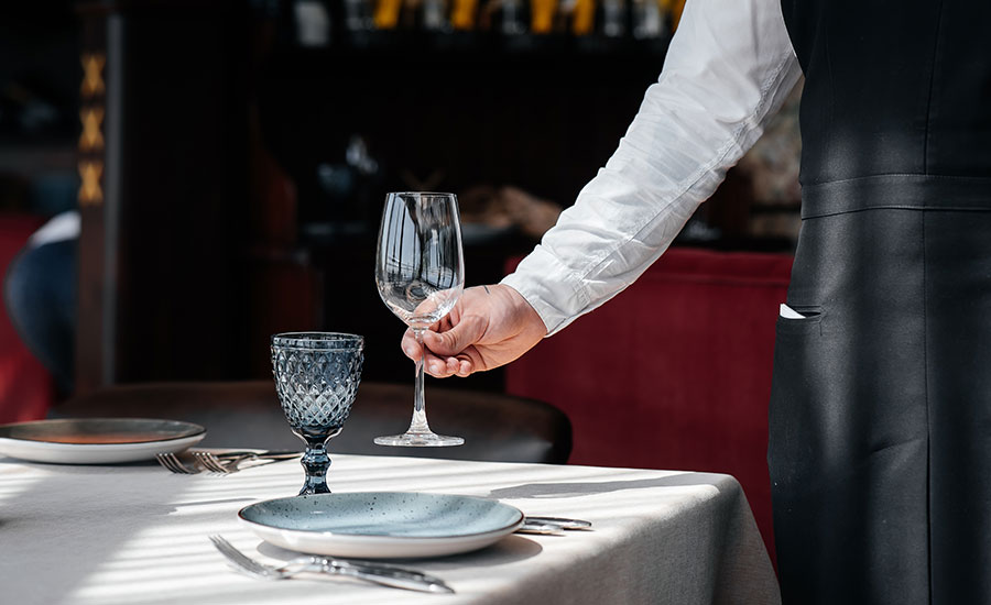 A restaurant server setting the table