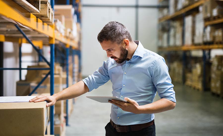 A warehouse employee holding a tablet