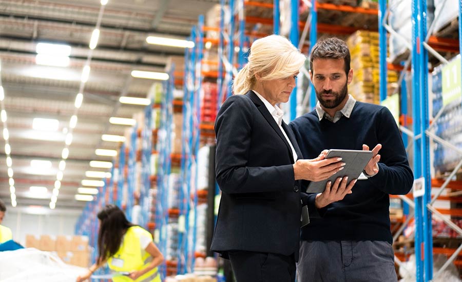 Two warehouse employees looking at a tablet