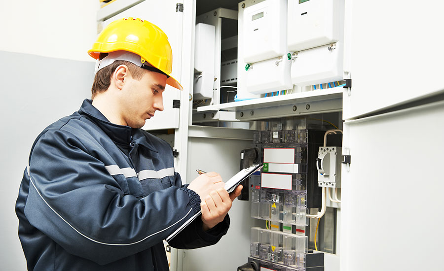 An image of an electrical inspector writing on a checklist