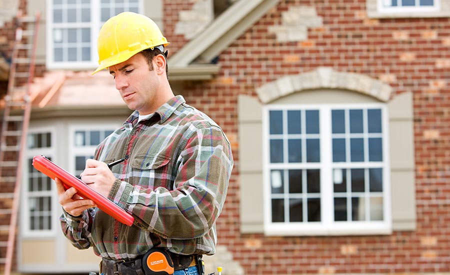 An inspector outside a brick house