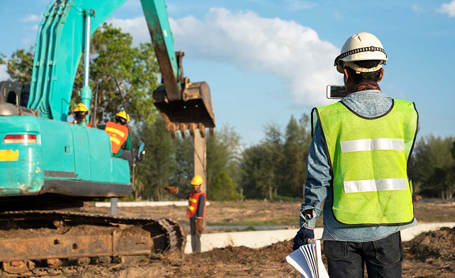 A construction worker taking pictures of the site