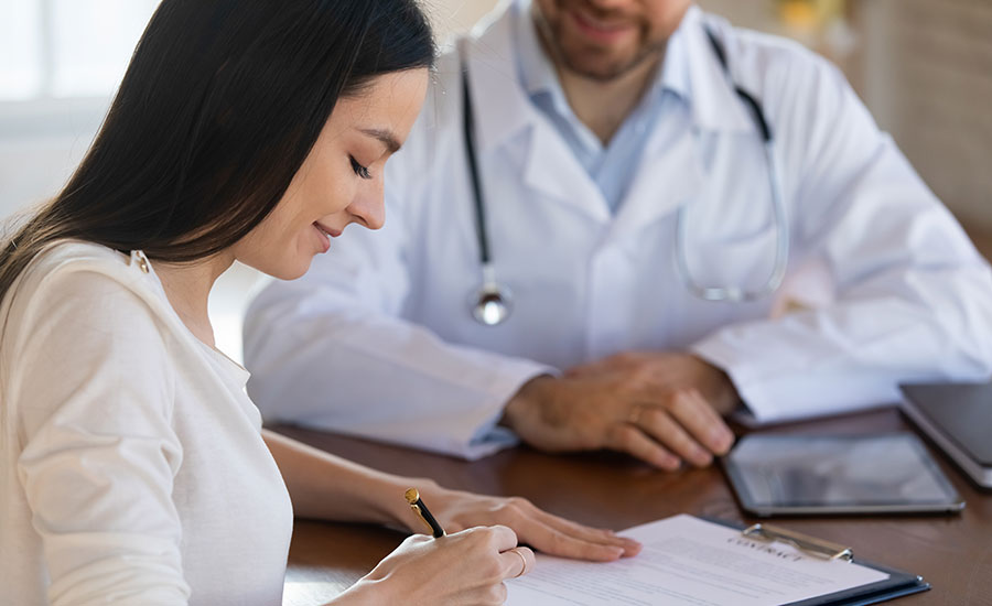 A woman signing a waiver in a doctor's office​