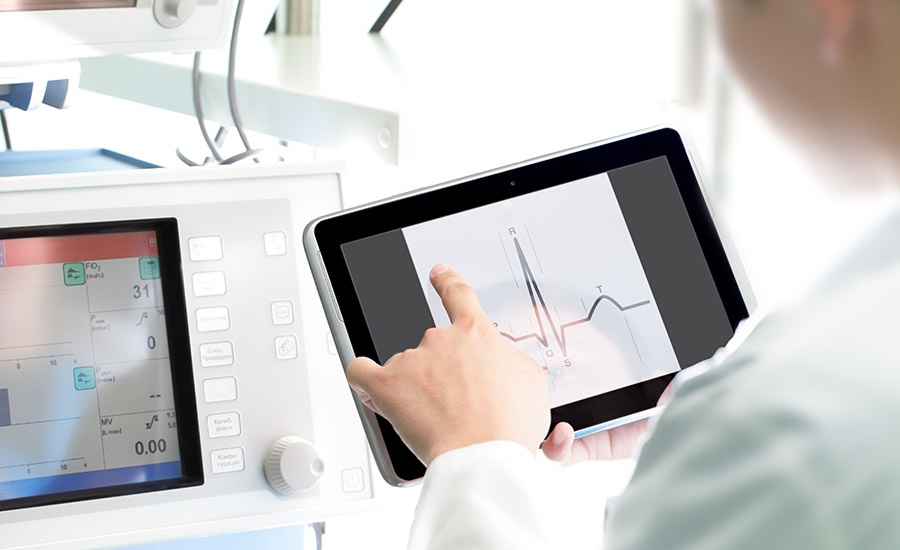 A doctor looking at medical examination results on a tablet​