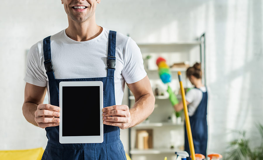 A man from a professional cleaning company holding a tablet​