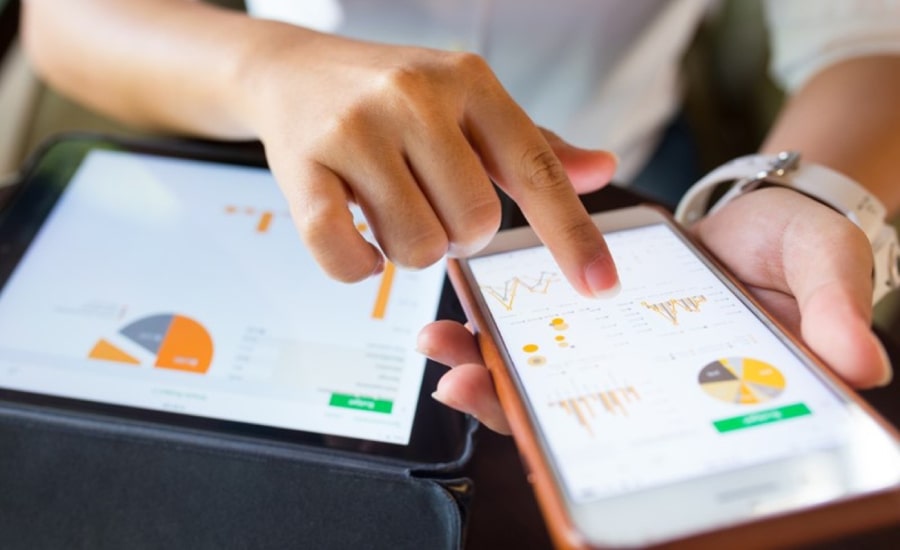 A woman checking business results on her smart phone​