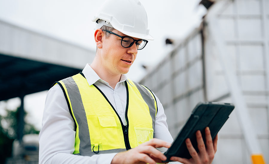 A safety inspector with a tablet on a construction site​